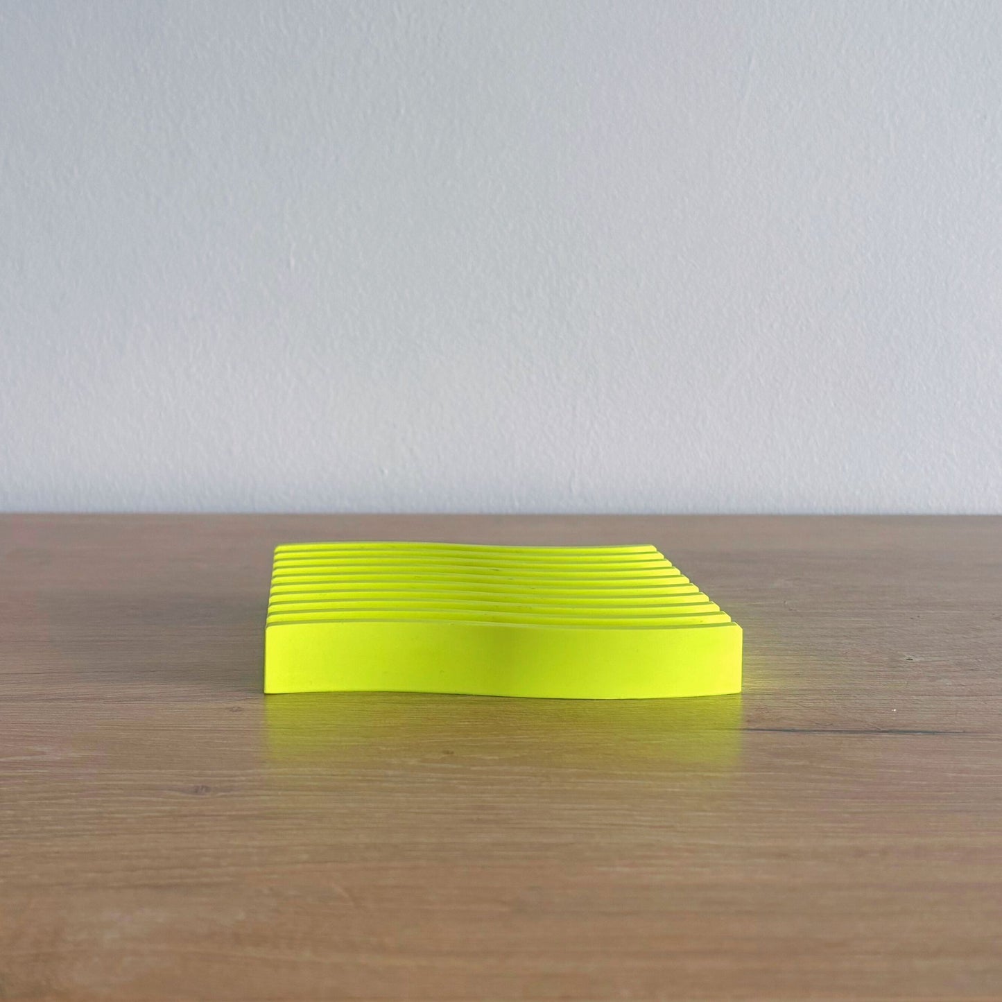 neon yellow wave tray coaster size on wooden shelf