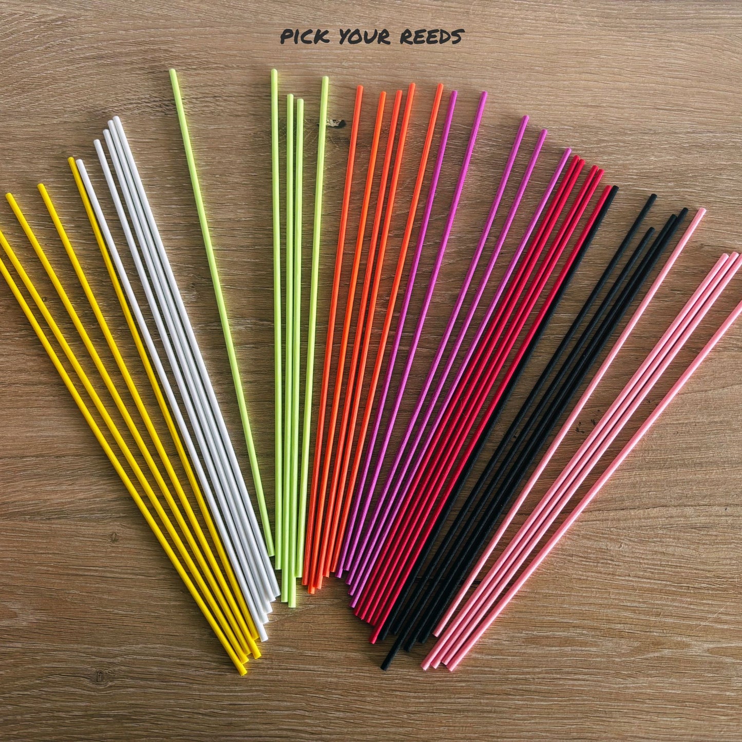 Colorful diffuser reeds in various colors on a wooden surface with text 'Pick Your Reeds'.