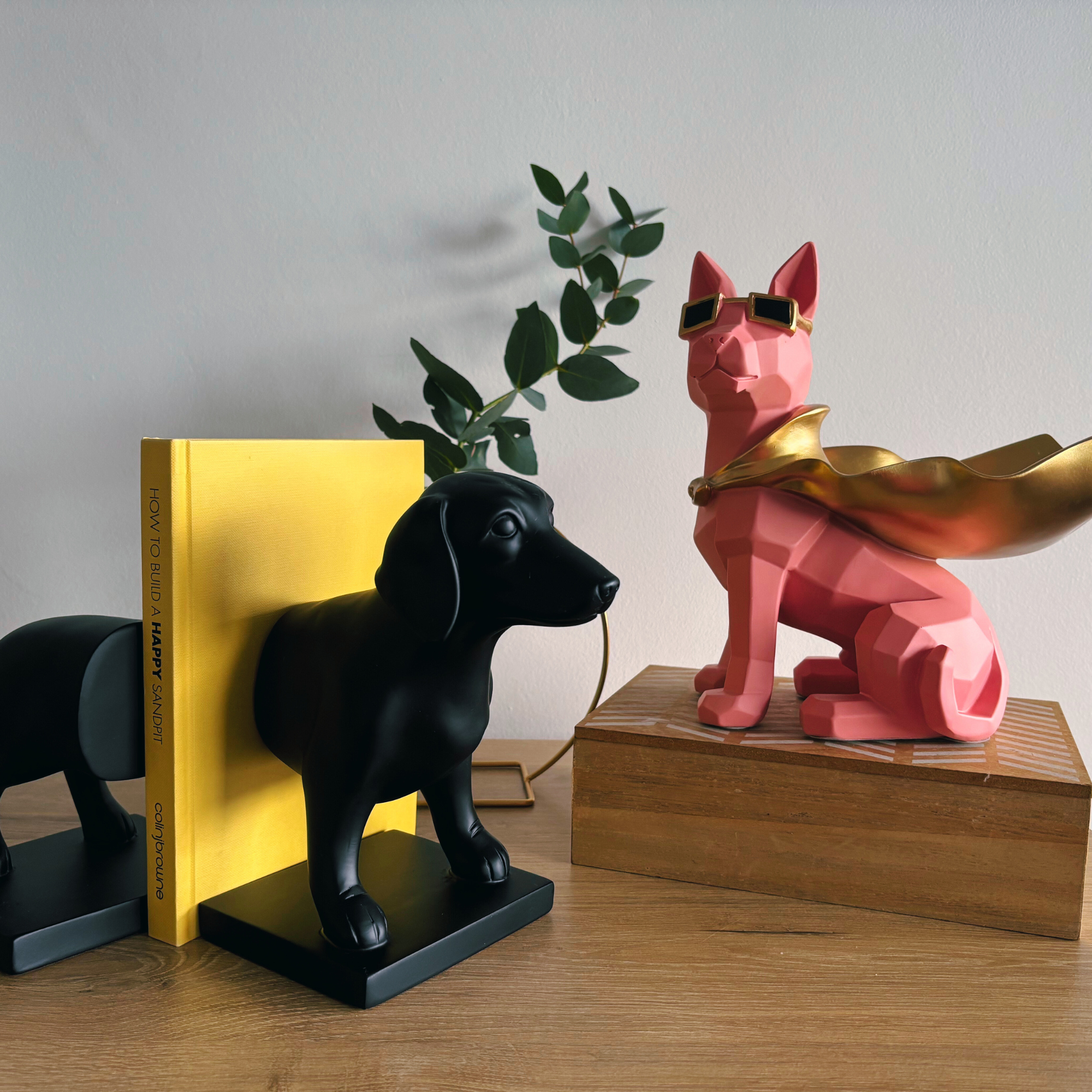 black dachshund bookends and pink dog ornament with gold cape 