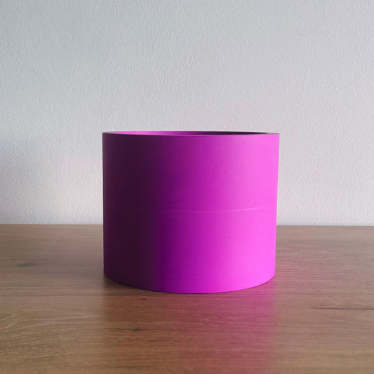 Purple cylindrical container on a wooden surface with a white background