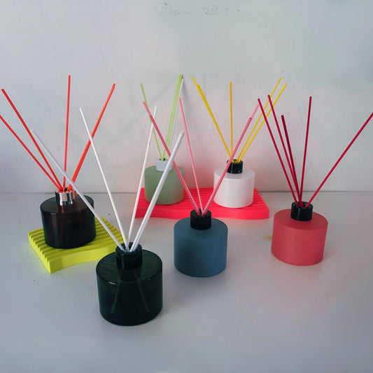 Colorful diffusers with sticks on a white background